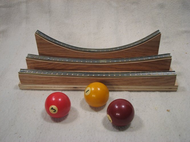 Stringless Pendulum Tracks: three billiard balls in front of curved wooden pendulum tracks